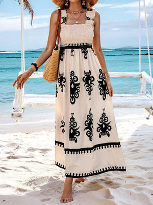 Cream maxi dress with black print, smocked bodice, square neck, and ruffled straps.