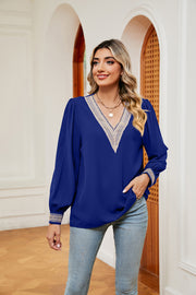 Royal blue blouson top with V-neck and embroidered trim on neckline and cuffs.