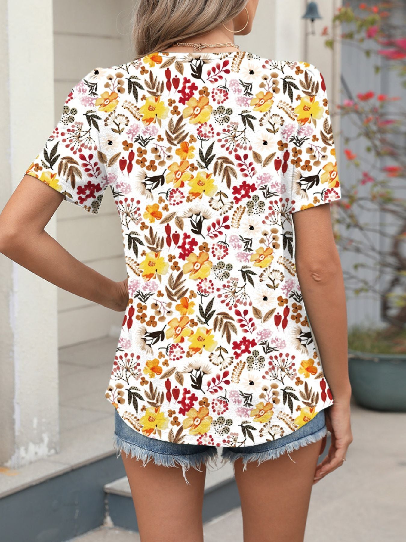Women's white short sleeve blouse with vibrant floral print.