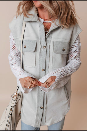Light gray utility vest with contrast trim and button-down front, styled with crochet sleeves.