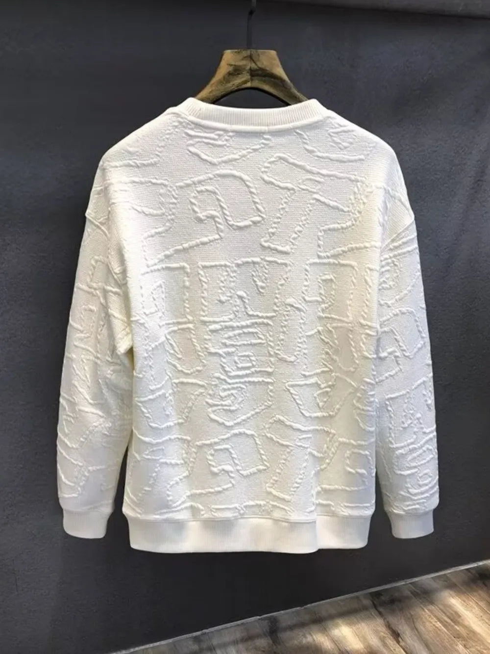 Ivory crewneck sweatshirt with allover embossed geometric texture.