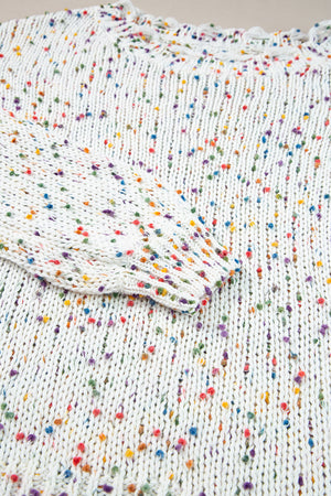 White confetti knit sweater with colorful flecks and distressed hem detail.