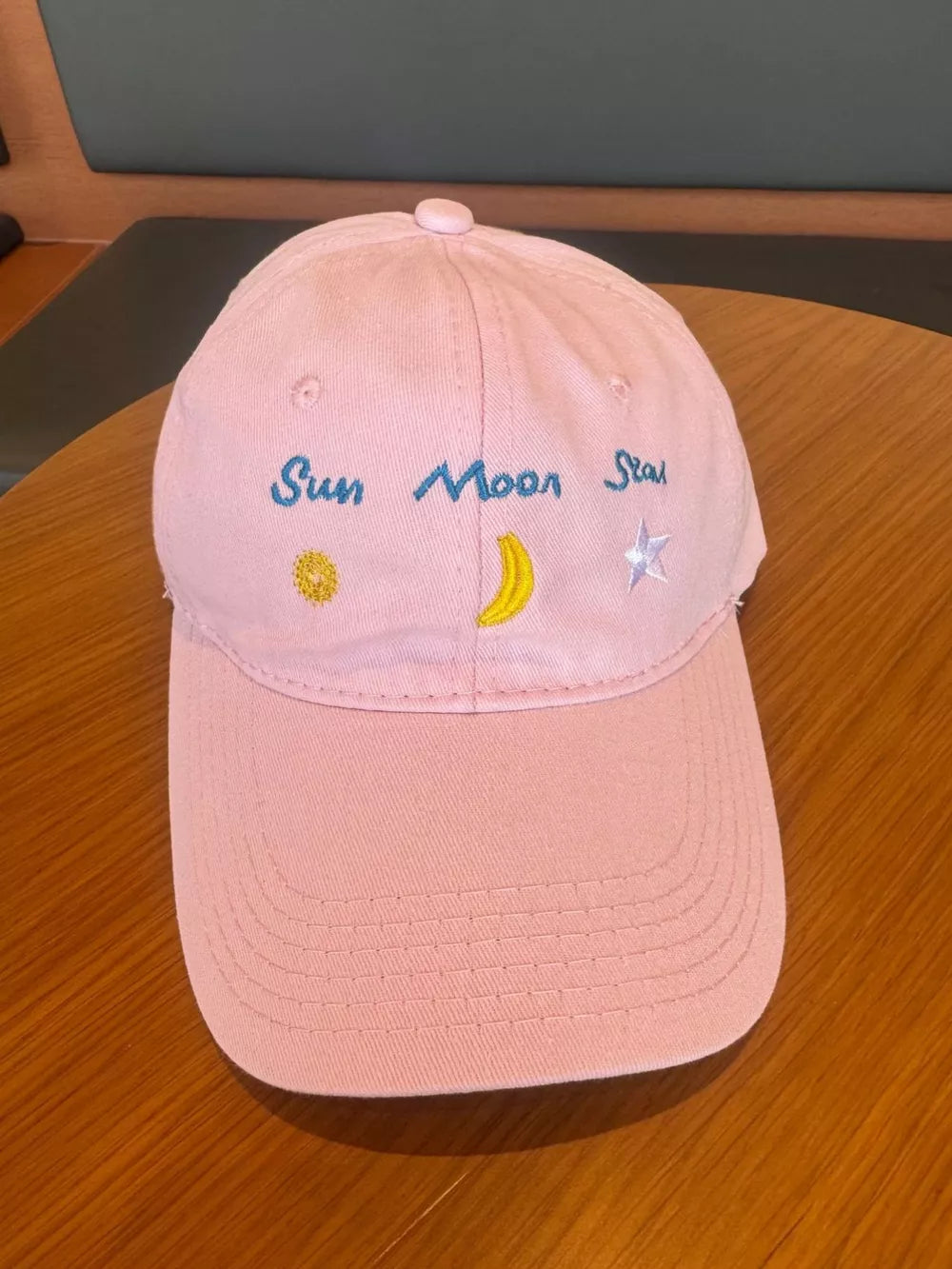 Blush pink cotton baseball cap with celestial embroidery and text.
