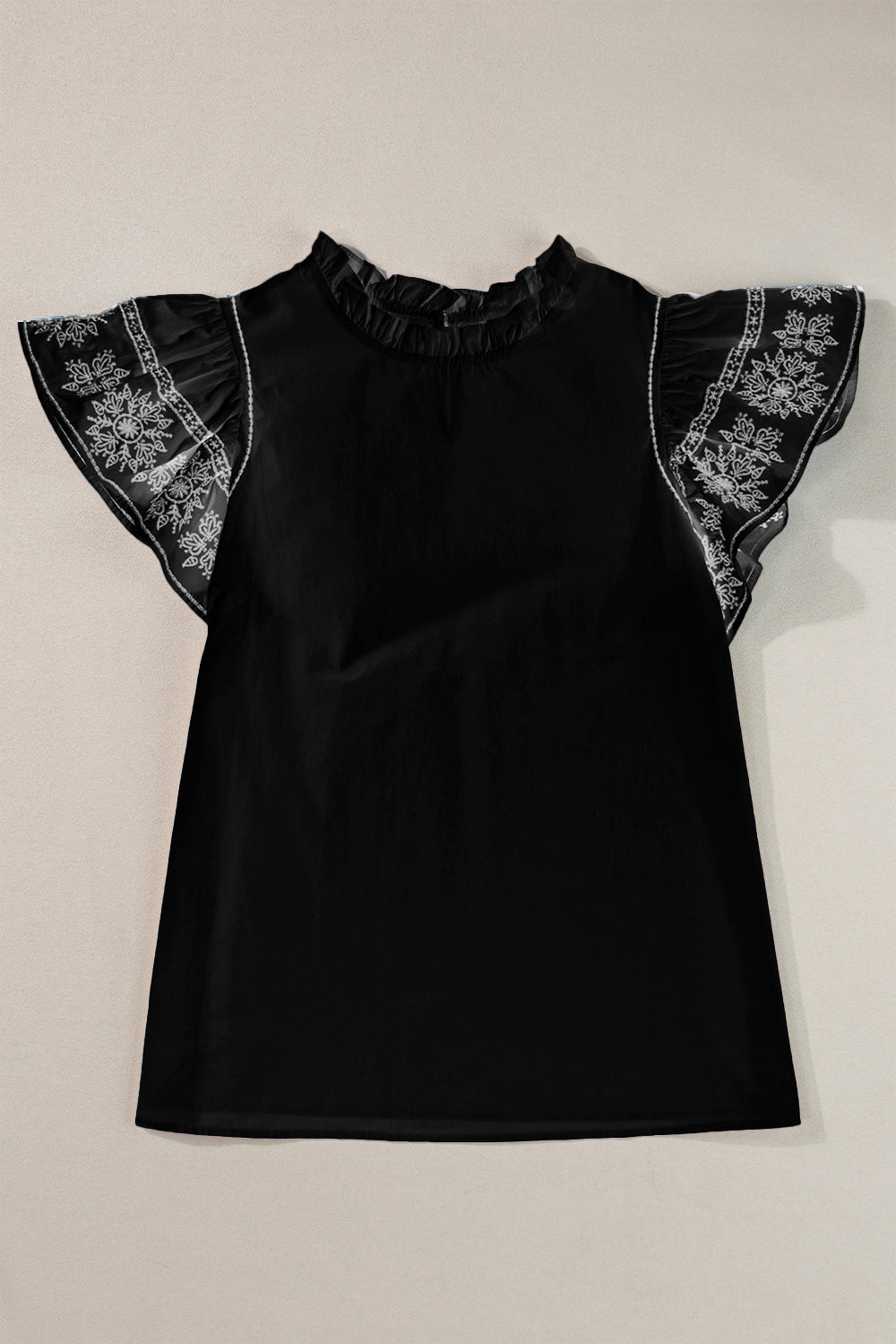 Black blouse with ruffled neckline and embroidered flutter sleeves.