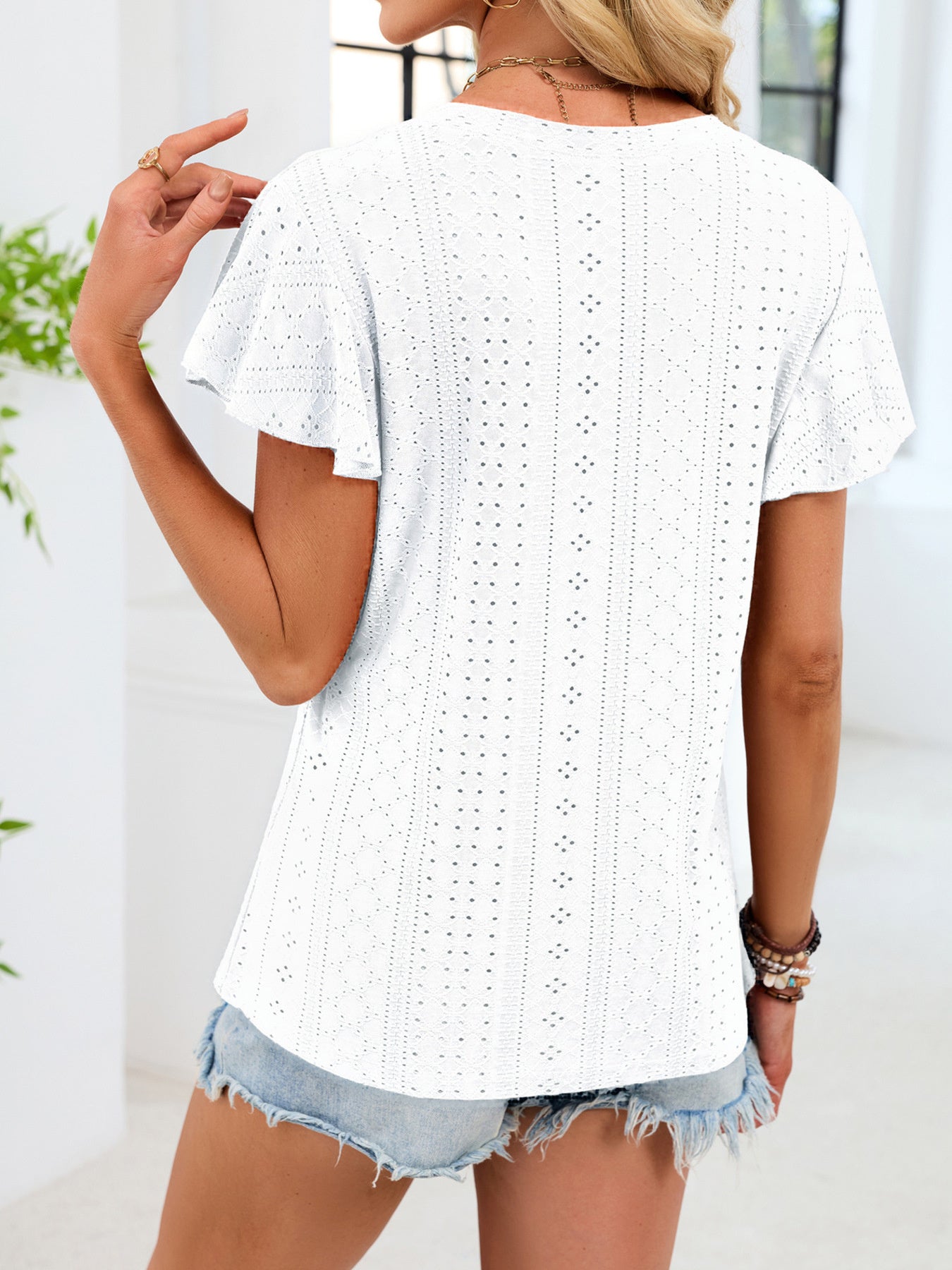 White eyelet t-shirt with flutter sleeves and a patterned texture.