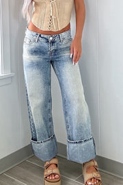 Medium washed denim trousers with cuffed hems and a relaxed fit.