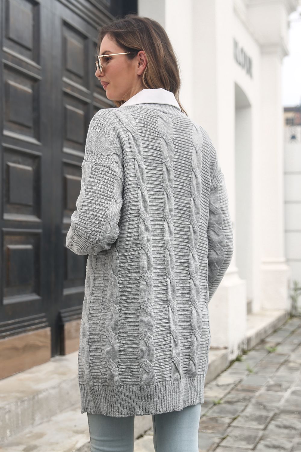 Longline cable knit cardigan in light gray acrylic with ribbed trim and crew neck.