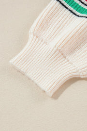 Ivory knit sweater sleeve detail with ribbed cuff and colorful stripe accent.