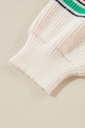 Ivory knit sweater sleeve detail with ribbed cuff and colorful stripe accent.