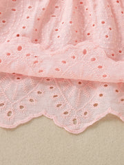 Pink cotton baby top with eyelet embroidery and scalloped hem detail.