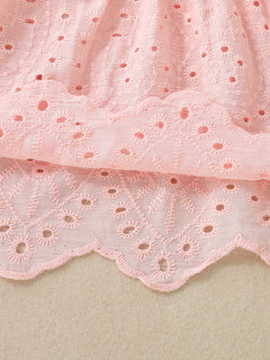 Pink cotton baby top with eyelet embroidery and scalloped hem detail.