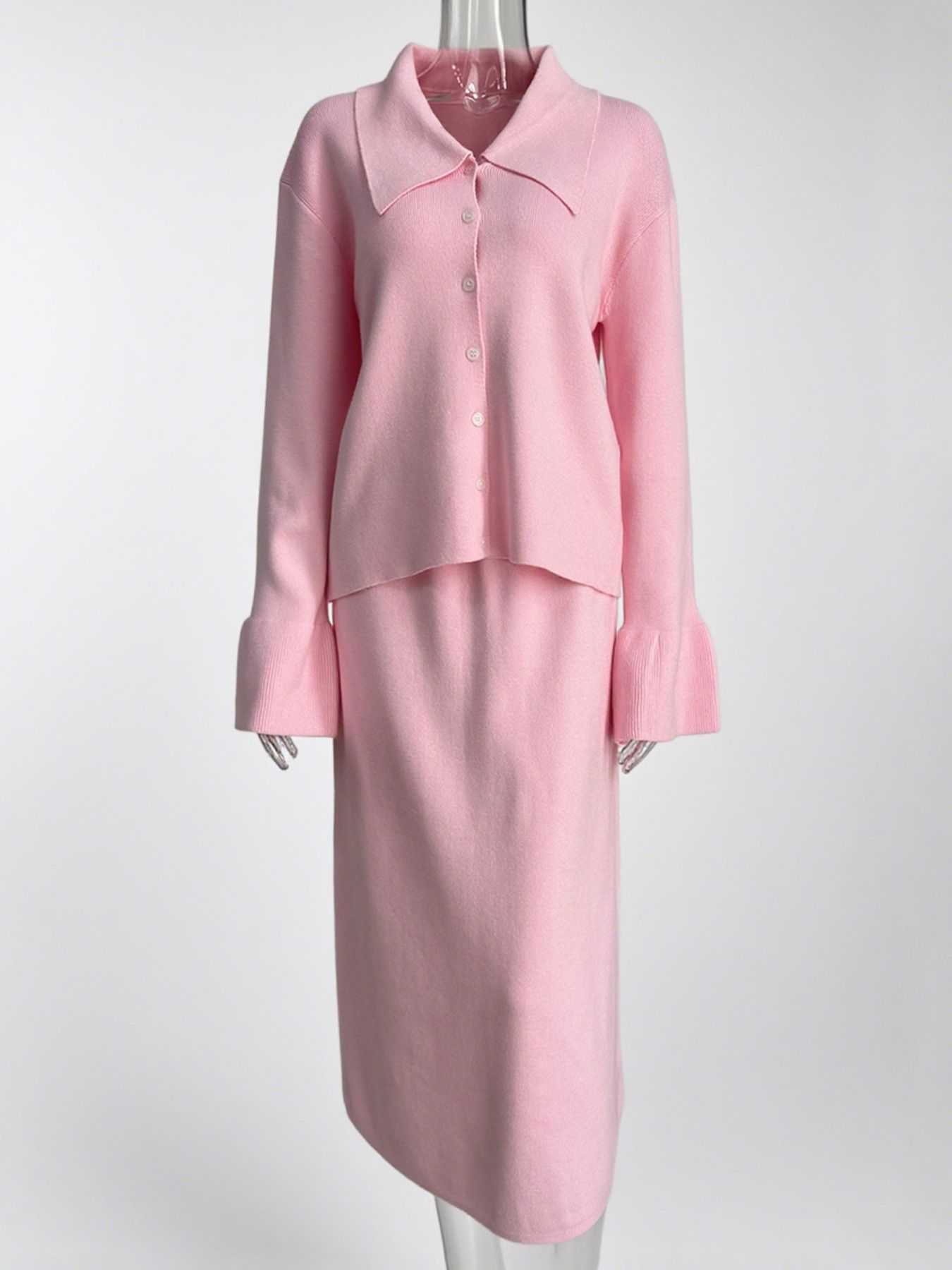 Pink ribbed knit cardigan with button-down front and flared cuffs, paired with a matching midi skirt.