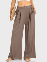 Pleated palazzo trousers with pockets in taupe, featuring a wide leg and elastic waistband.