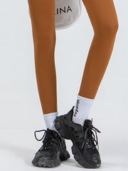 Caramel high-waist leggings with white socks and black sneakers.