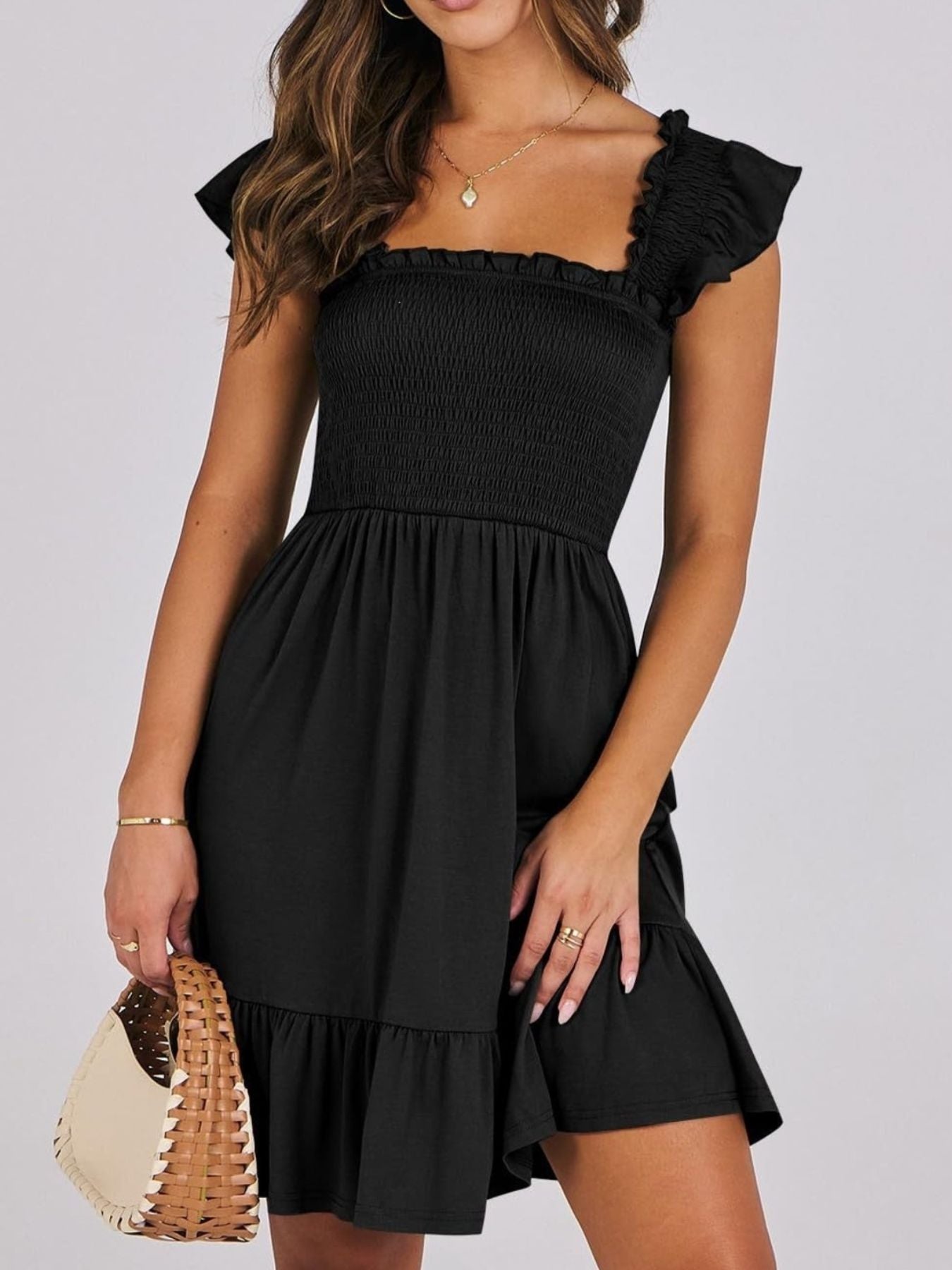 Black smocked ruffle hem mini dress with square neckline and flutter sleeves.