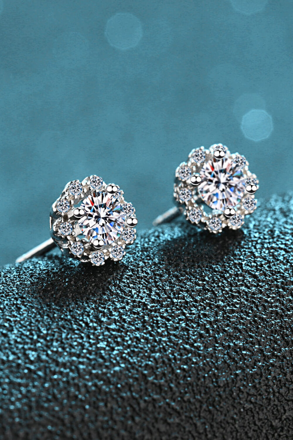 Floral halo stud earrings in silver with sparkling stones.