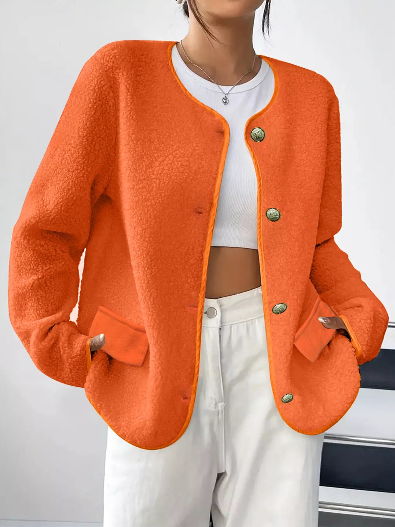 Orange textured button-up fleece jacket with round neckline and patch pockets