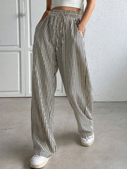 Wide-leg trousers with black and white vertical stripes, drawstring waist, and pockets.