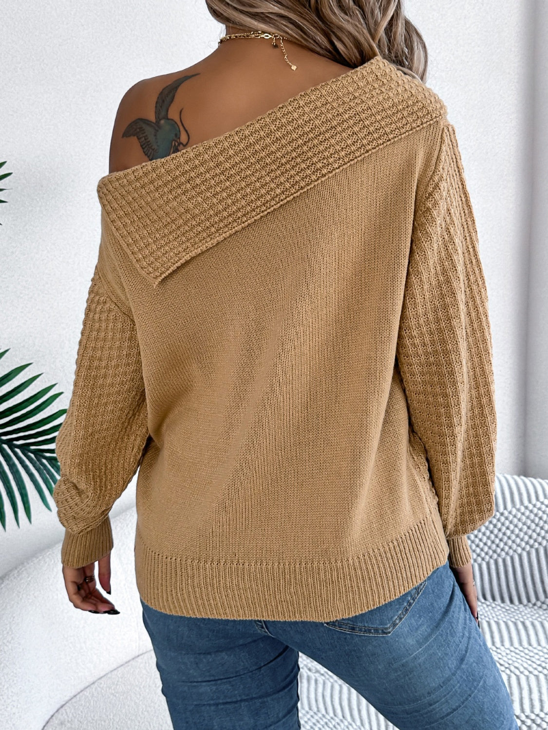 Camel off-shoulder cable knit pullover sweater with textured sleeves.