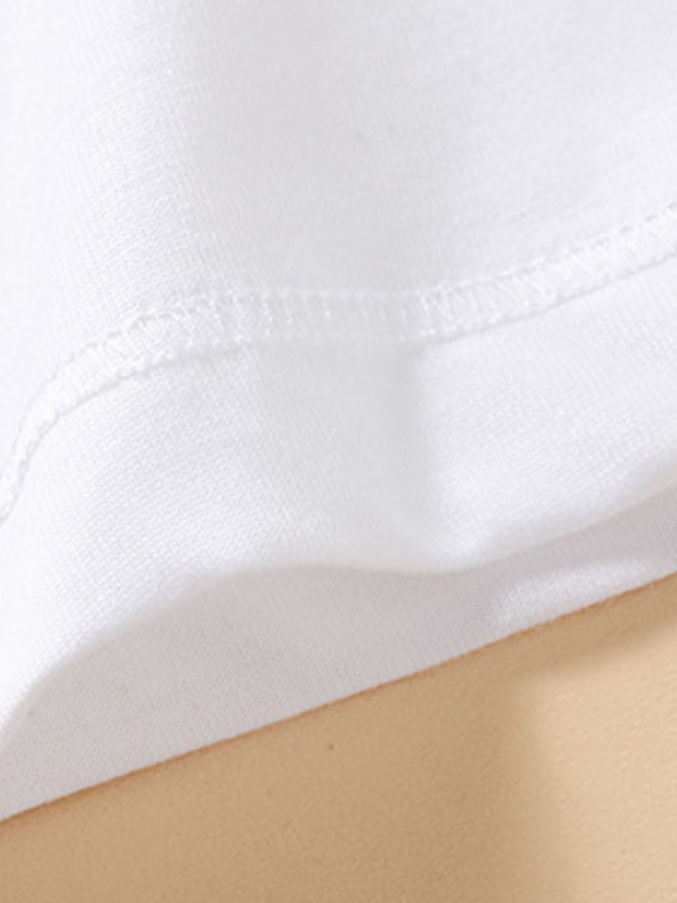 White cotton baby polo shirt detail showing stitching and fabric texture.