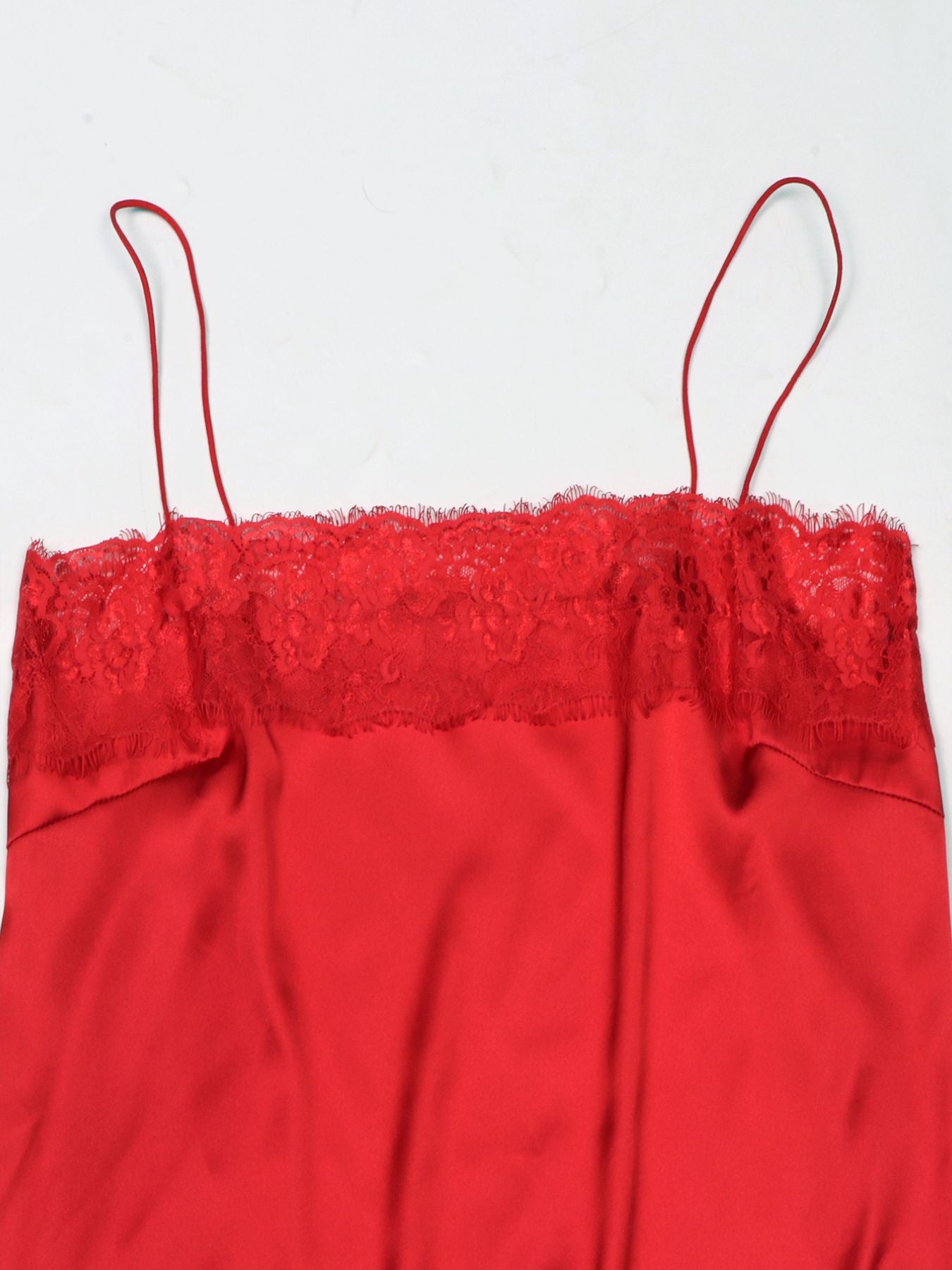 Red satin cami top with lace trim detail and thin spaghetti straps.