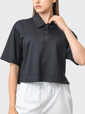 Black cropped polo sportif top with short sleeves and a button placket.