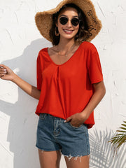 Red orange t-shirt with pleats at neckline, short sleeves, and a relaxed fit.