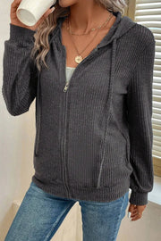 Dark gray textured ribbed knit zip-up hoodie with drawstring hood and pockets.
