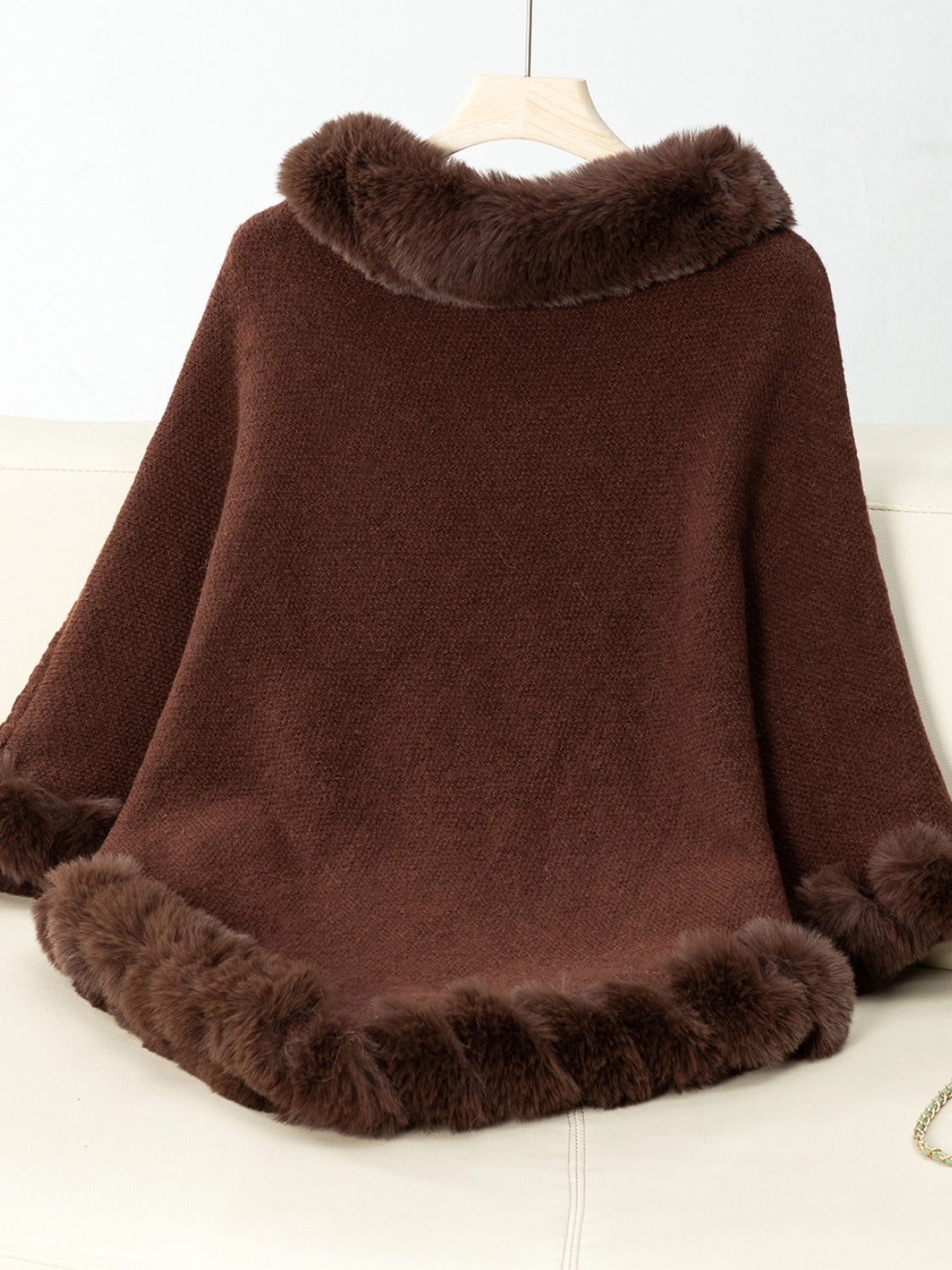 Chocolate knit poncho with faux fur trim at neckline and hem.