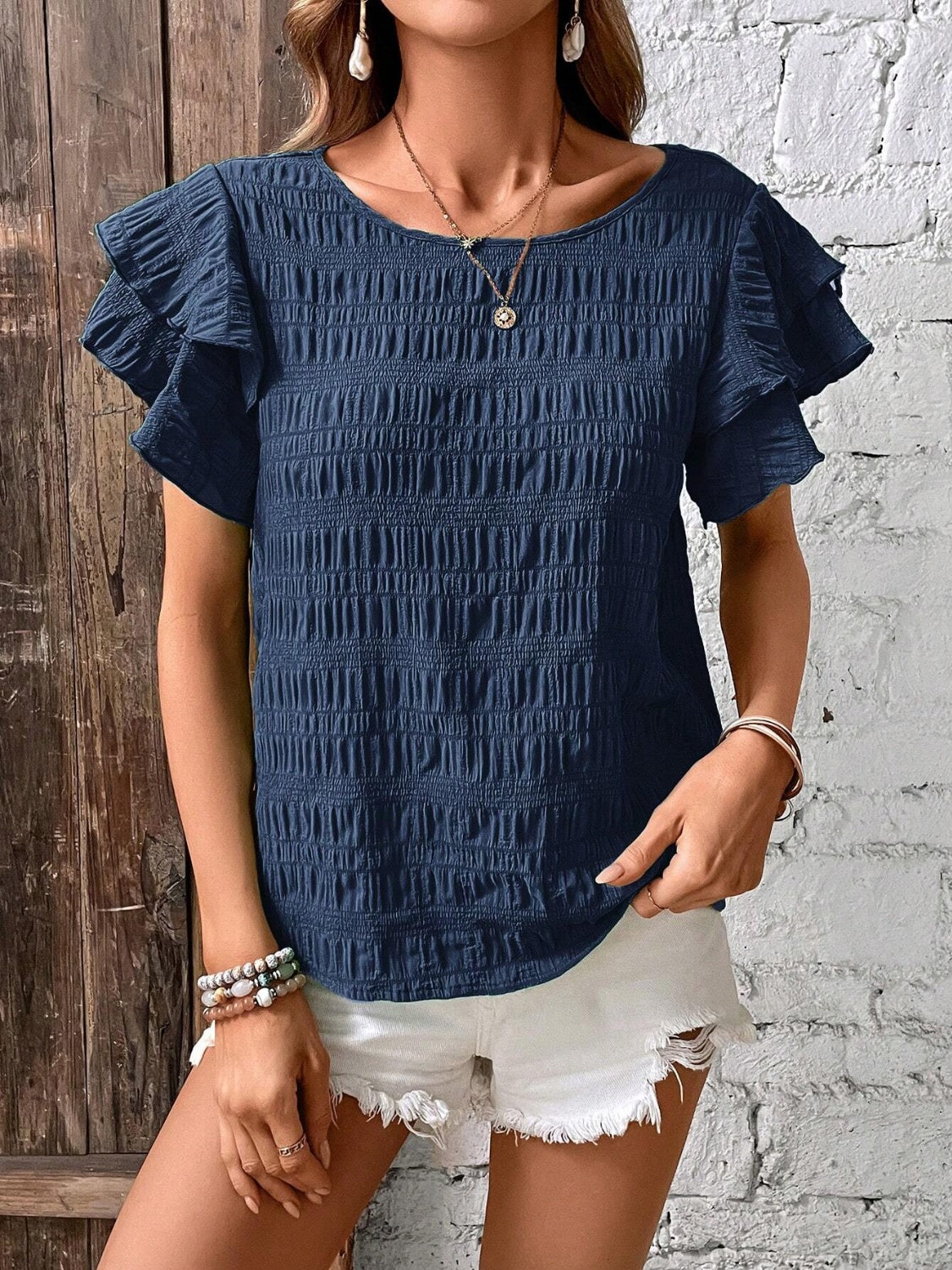 Dark blue smocked blouse with ruffle sleeves and textured fabric