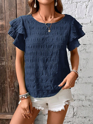 Dark blue smocked blouse with ruffle sleeves and textured fabric