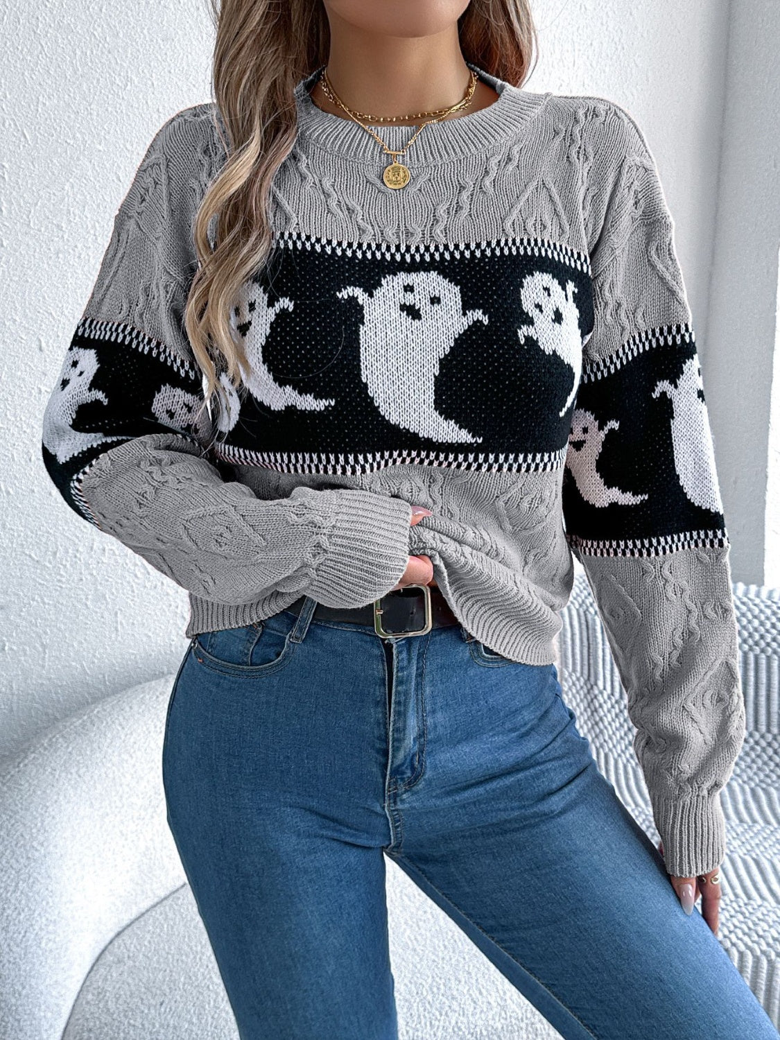 Gray cable knit crewneck sweater with a black and white ghost motif pattern.