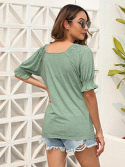 Sage off-shoulder ruffled sleeve top with square neckline and cinched cuffs.