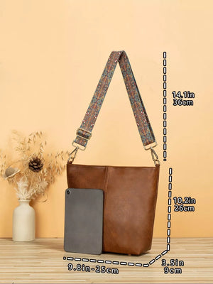 Tan pu leather crossbody bag with geometric strap and tablet for scale.