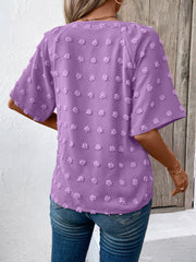 Heliotrope purple Swiss dot blouse with short sleeves and a V-neckline.