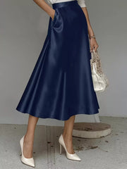 Navy blue A-line satin skirt with pockets, midi length, flowing silhouette.