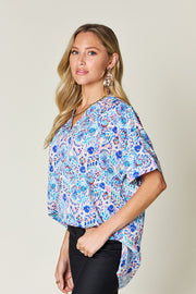 Floral ikat relaxed v-neck top in sky blue with short sleeves and a loose fit.
