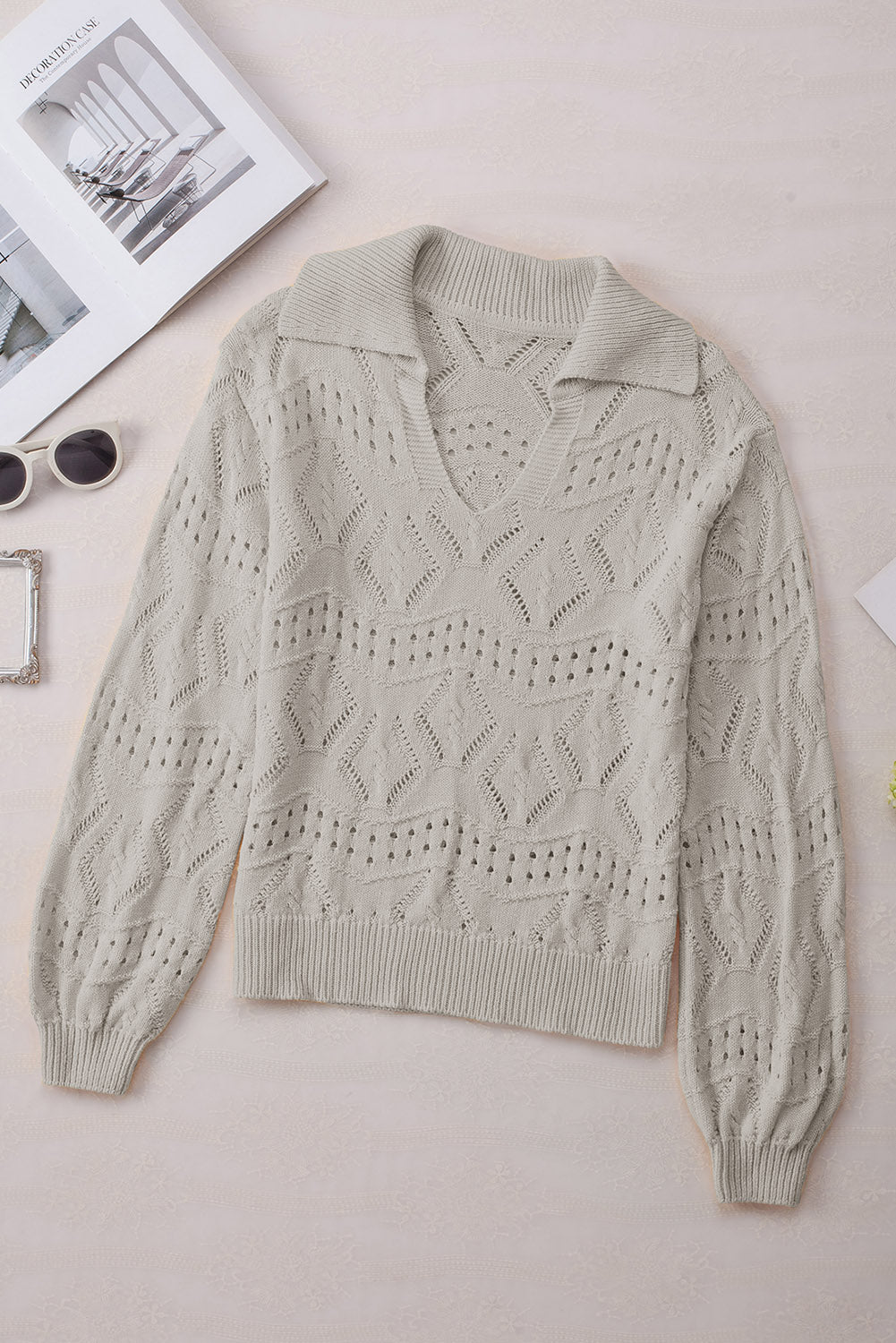 Gray openwork collar knit sweater with V-neck and long sleeves.