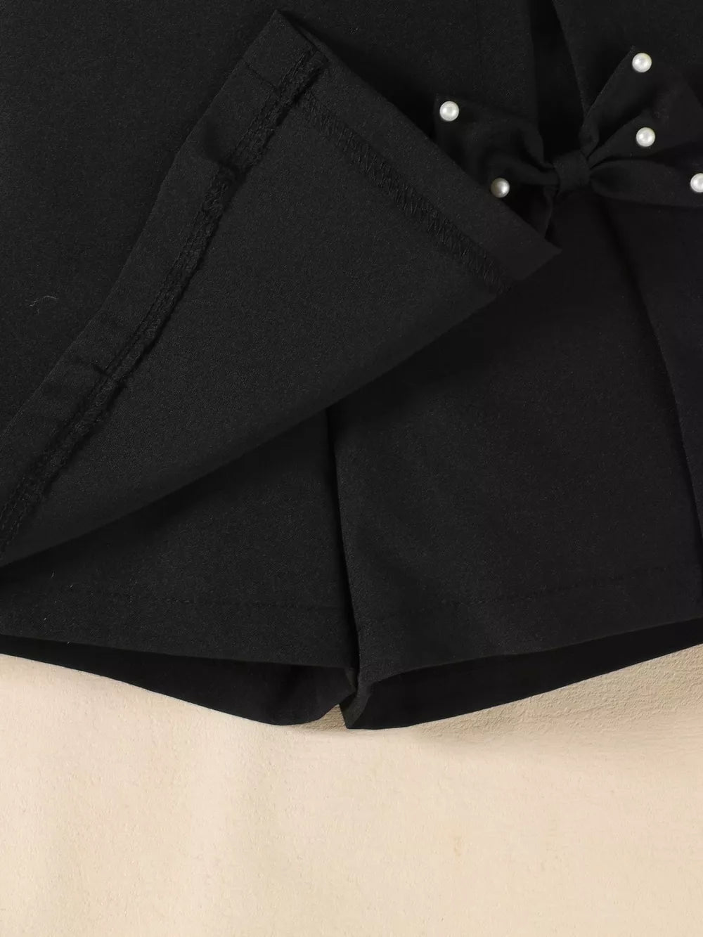 Black baby skort set with pearl-embellished bow detail
