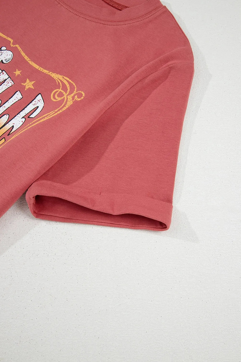 Burnt coral graphic t-shirt with rolled sleeves and distressed Music City text.