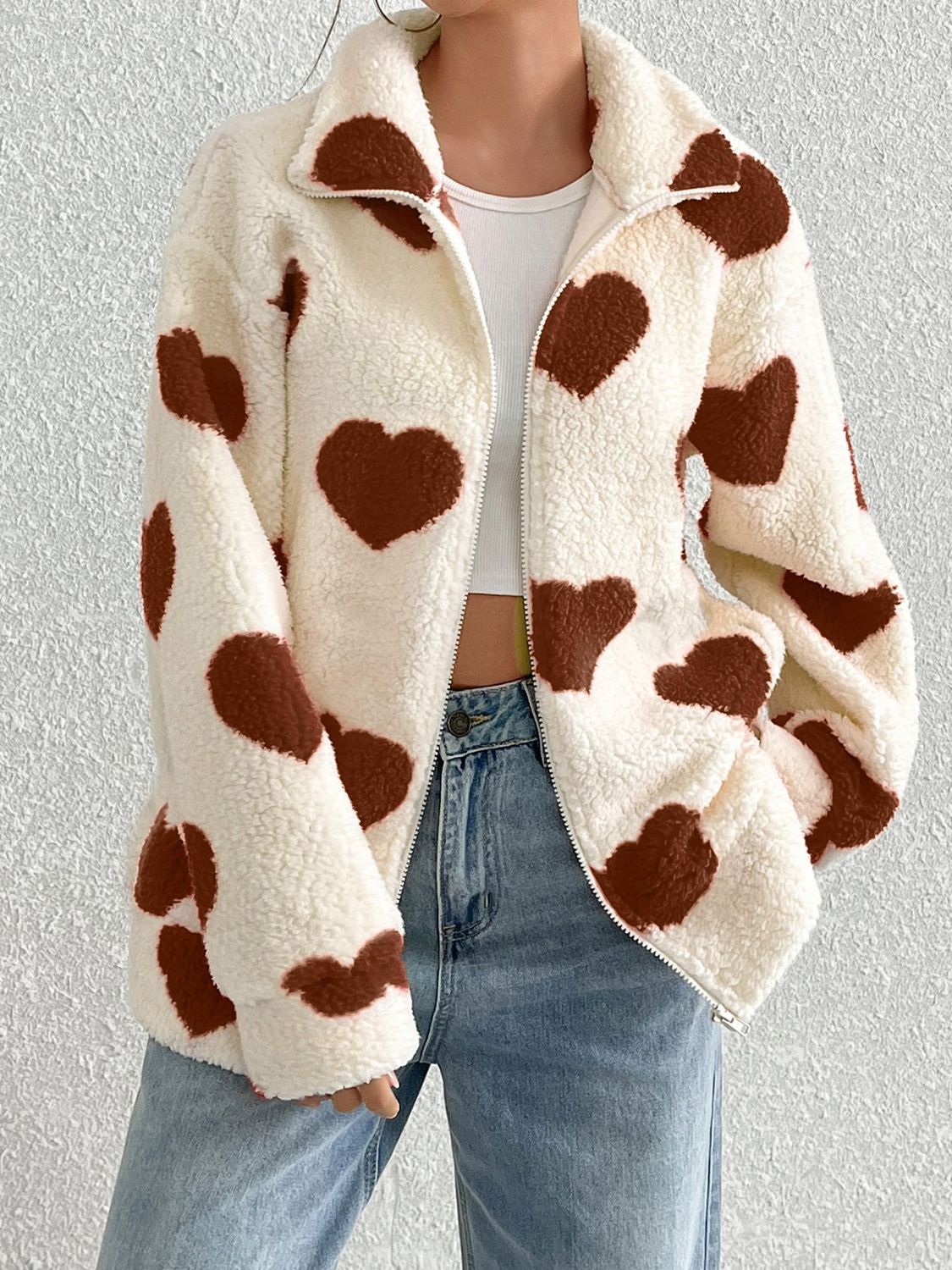 Heart print sherpa zip-up jacket with a spread collar and full zip closure.