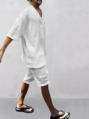 White cable-knit V-neck two-piece set with short sleeves and shorts.