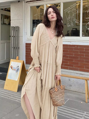 Apricot smocked V-neck tiered maxi dress with long sleeves and ruffled cuffs.