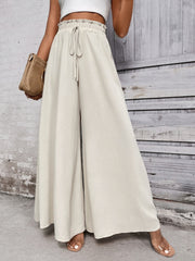 Beige ruffled waistline palazzo trousers with drawstring and wide legs.
