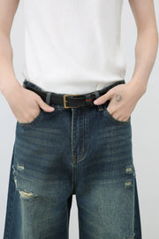 Distressed baggy denim jeans in dark wash with ripped details.