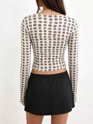 Sheer polka dot maternity shirt with long sleeves and a round neckline.