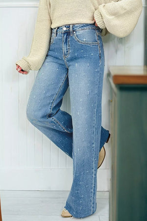 High-rise light wash denim jeans with distressed details and raw hem.