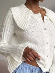 White acrylic cardigan with oversized collar and pearl buttons, ribbed sleeves.