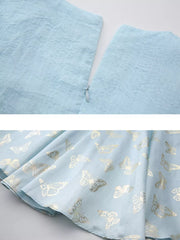 Light blue midi dress with gold butterfly print and cinched waist detail.