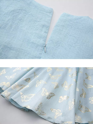 Light blue midi dress with gold butterfly print and cinched waist detail.